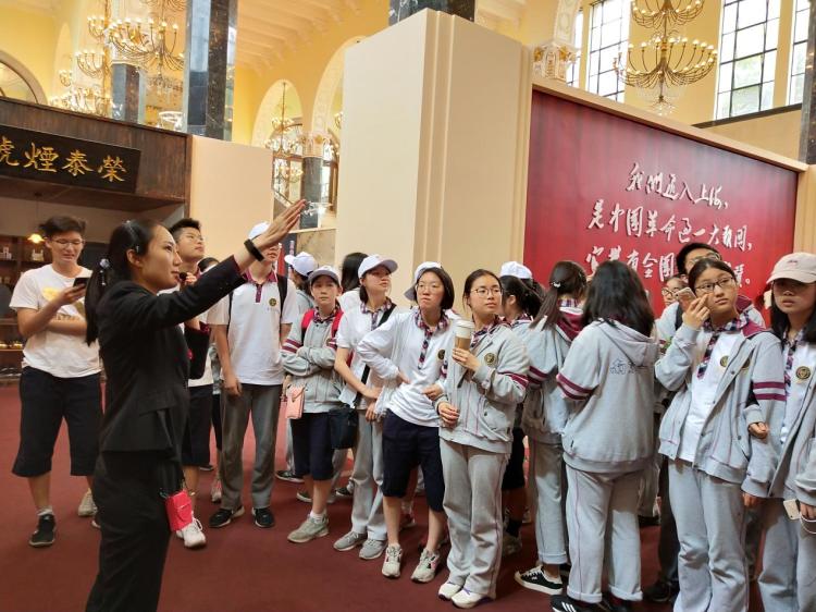 学生在认真听讲解员介绍上海发展历史