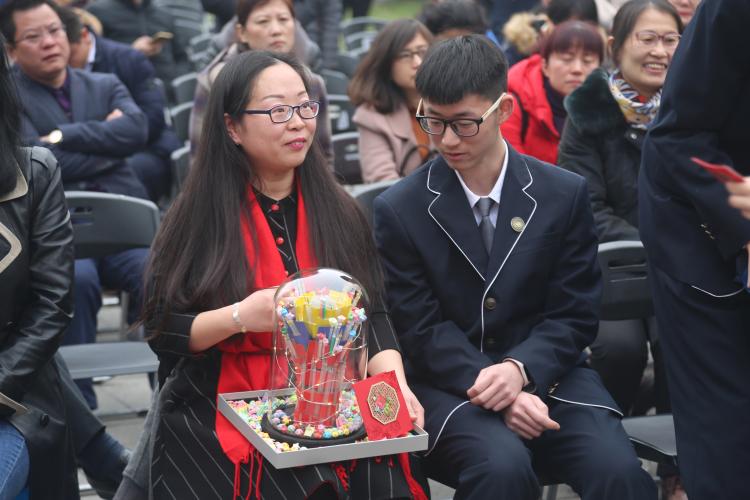 邱天禹妈妈用儿子写空的100支笔芯制作的礼物既像祝贺成人的蛋糕，又像庆祝胜利的奖杯，寓意“百炼成钢”