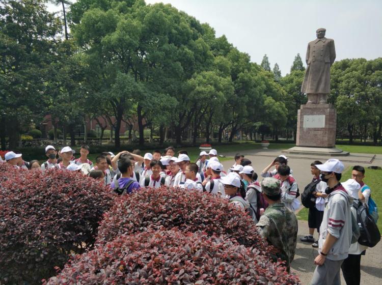 学生在毛泽东像前听研学导师介绍复旦大学