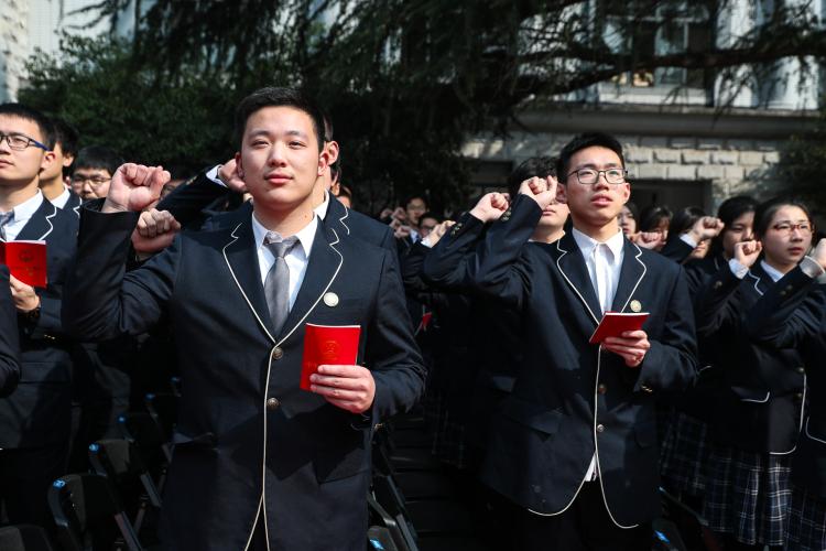 .学生们手持宪法，面向国旗庄严宣誓