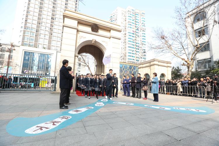 同学们在老师和家长的欢迎下进入成人门，踏上标有”修身、齐家、治国、平天下“的成人”路